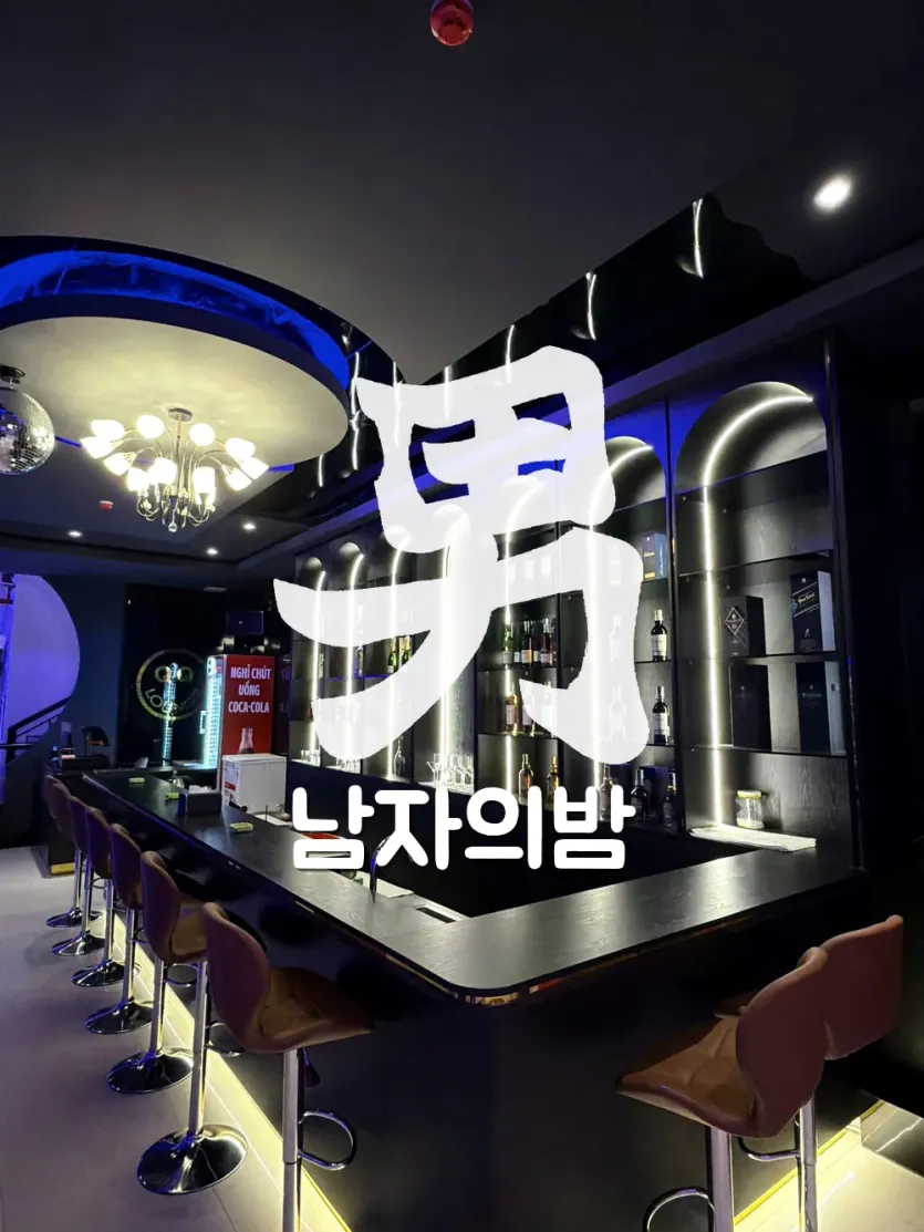 다낭 QQ LOUNGE 바 카운터와 아치형 조명 선반의 위스키 진열