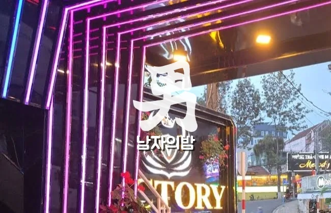 달랏 빅토리 가라오케 보라색 네온이 둘러진 입구와 로고 간판
