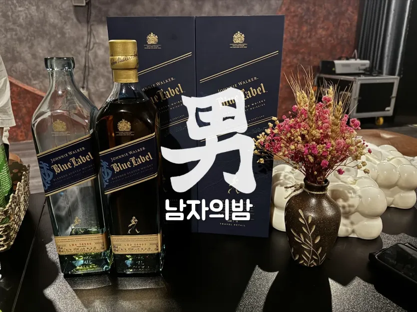 나트랑 버니바 테이블에 놓인 조니워커 블루라벨 위스키 병과 상자, 드라이플라워 화병